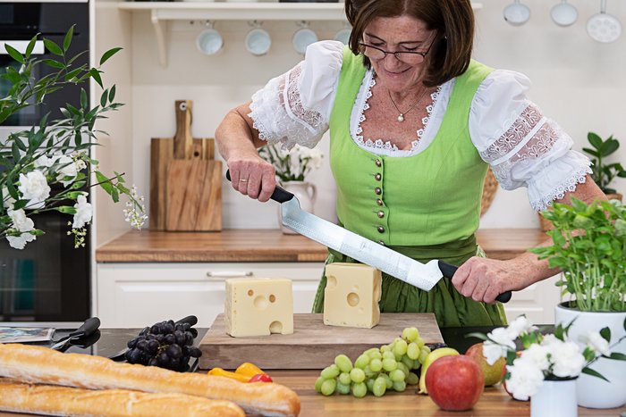 Frau schneidet Käse in der Küche